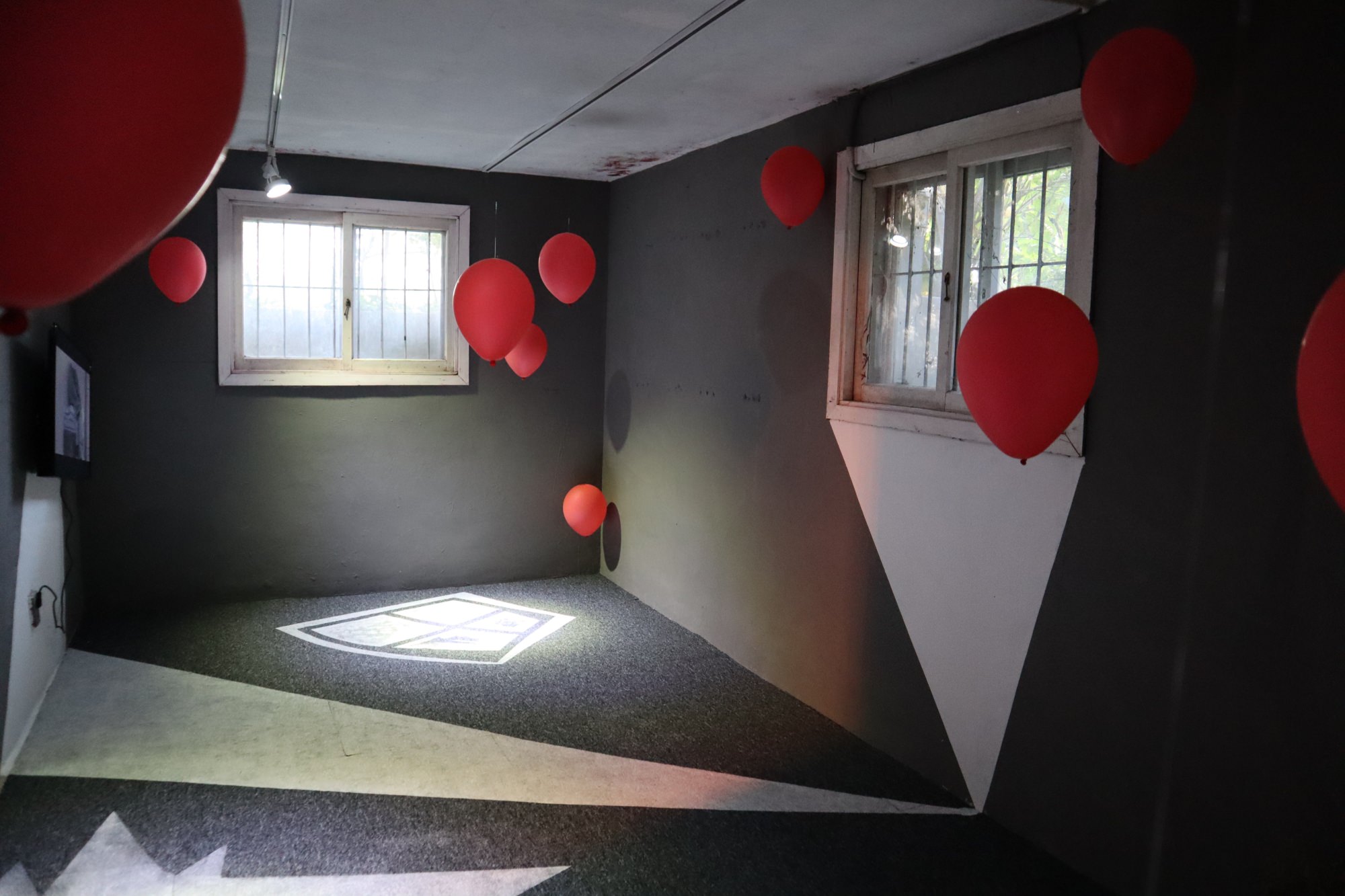 구멍 난 현실3, 2020, 설치, 벽과 바닥 위에 그림과 영상(풍선과 검은 옷을 입은 수상한 자들), 가변크기